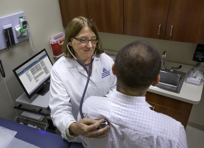 Nancy Klimas, M.D., co-principal investigator and director of Nova Southeastern University’s College of Osteopathic Medicine’s Institute for Neuro Immune Medicine, checks a patient’s vital signs.