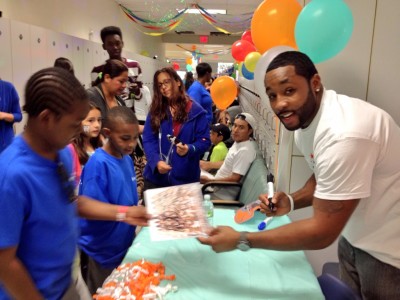 Miami Dolphins player Marcus Thigpen signs autographs for children at Nova Southeastern University College of Dental Medicine’s Give Kids a Smile Day