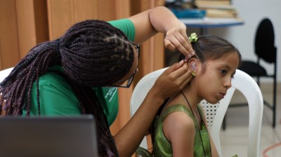 Nova Southeastern University doctor of audiology student Judith Lynch fitting 7-year-old Cristiane Ordoñez with her new hearing aids.