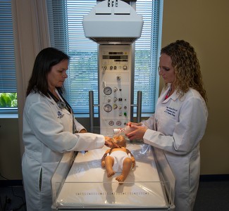 Marianne Jankowski, DHSc., RRT, chair of NSU’s Department of Cardiopulmonary Sciences and director of the Respiratory Therapy Program, and Jennifer Bencsik, MHA, RRT, assistant professor of cardiopulmonary sciences in NSU’s Department of Cardiopulmonary Sciences, demonstrate infant CPR in NSU Palm Beach’s simulated 10-bed intensive care unit.