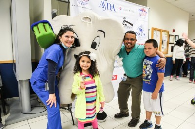 Aline Medina, D.D.S. (right), first year pediatric dental resident at NSU’s College of Dental Medicine, welcomes a young girl to Give Kids a Smile Day 