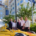 Marc Cannon, Chief Marketing Officer and Senior Vice President, AutoNation; Dr. Jacqueline A. Travisano, Chief Operating Officer and Executive Vice President, Nova Southeastern University (NSU); Ronald G. Assaf, Chair, NSU Board of Trustees; Ryan Hunter-Reay, Indianapolis 500® Champion and Founder of Racing for Cancer; Dr. Jennifer O’Flannery Anderson, NSU Vice President for Advancement and Community Relations; with the car in which Hunter-Reay won the 2014 Indianapolis 500®
