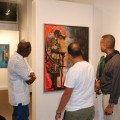 Viewing the painting "Pilgrim of the Future" by Gregory Vorbe  are on the left Kristo Nicolas, Haitian artist; middle, Gregory Vorbe, Haitian artist; with (on the left)  Alex Jospitre, Consulate General of Haiti in Orlando, Florida.