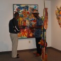 Viewing the painting "Another Call From Africa" are  (on the right) Babacar M'Bow, Exhibit Curator,  and (on left) Alex Jospitre, Consulate General of Haiti in Orlando, Florida.