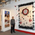 Jerry Kraig poses next to his artwork in the Gallery.