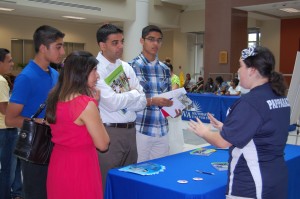 A student and his family speak with orientation representatives about upcoming activities on campus.