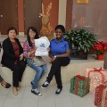 Student Ambassadors Shemaiah Kenon (left) and Rebecca Fils-Aime (right) and a visiting family enjoy the holiday decorations at the Holiday Campus Preview.