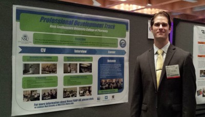 Pharmacy student Matt Brooks poses in front of the poster he and fellow students presented at the conference