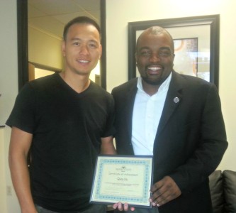 Michael Daniels, Orlando campus director presents Quay Hu, MBA with a certificate and wishes of congratulations. 