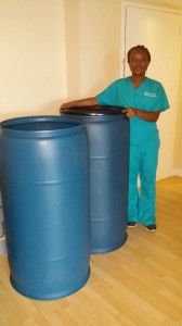 Marie-Gilberte “GG” Thermidor, an entry-level nursing student at NSU, poses with barrels of supplies she collected for school children in Haiti