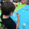 A young scientist learns how to use a pipet to exratct his DNA from a test tube  using supplies provided by the BioRad Science Ambassador Program.