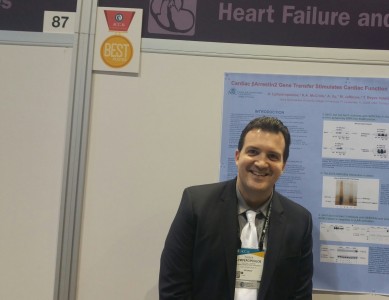 Anastasios Lymperopoulos, B.Pharm., M.Sc., Ph.D., F.A.H.A., F.E.S.C., poses with his winner poster