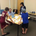 Evan Haskell, Ph.D., professor at the Halmos College of Natural Sciences and Oceanography, and mathematics major Ly Nguyen teach kids how to make accurate predictions using mathematical concepts at a STEM Programs for Children session presented by college faculty and students.