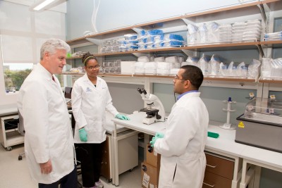 Research will be emphasized in the NSU College of Allopathic Medicine’s innovative curriculum. Pictured: Johannes W. Vieweg, M.D., FACS, founding dean, speaks with Julia James, Ph.D, post-doctoral researcher, and Ron Thomas, B.Sc., research assistant, in the NSU Cell Therapy Institute laboratory.