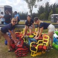 Class of 2019 students, from left, Stephanie O’Leary, Alice Nimmo, and Brittany Inerfeld prepare specialized safety equipment to ensure an exciting Adaptive Sports Day for disabled athletes.