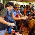 Ashley Sweat and Leann Whitt check children for head lice in Guatemala.