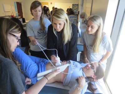 From left, class of 2018 students, Leann Whitt, in back, from left, Kathryn Hankins, Aubrie Hodges, and Megan Thompson, gather around Vanessa Hernandez, (on the exam table) as they execute ultrasound procedures learned during their recent POCUS training.