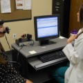 Two former graduate students are demonstrating nasometry, which is an acoustic tool in the clinic that provides quantitative data in the diagnosis of hpernasality versus denasality.