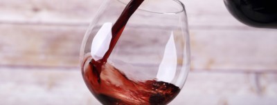 Pouring wine into glass and wooden background